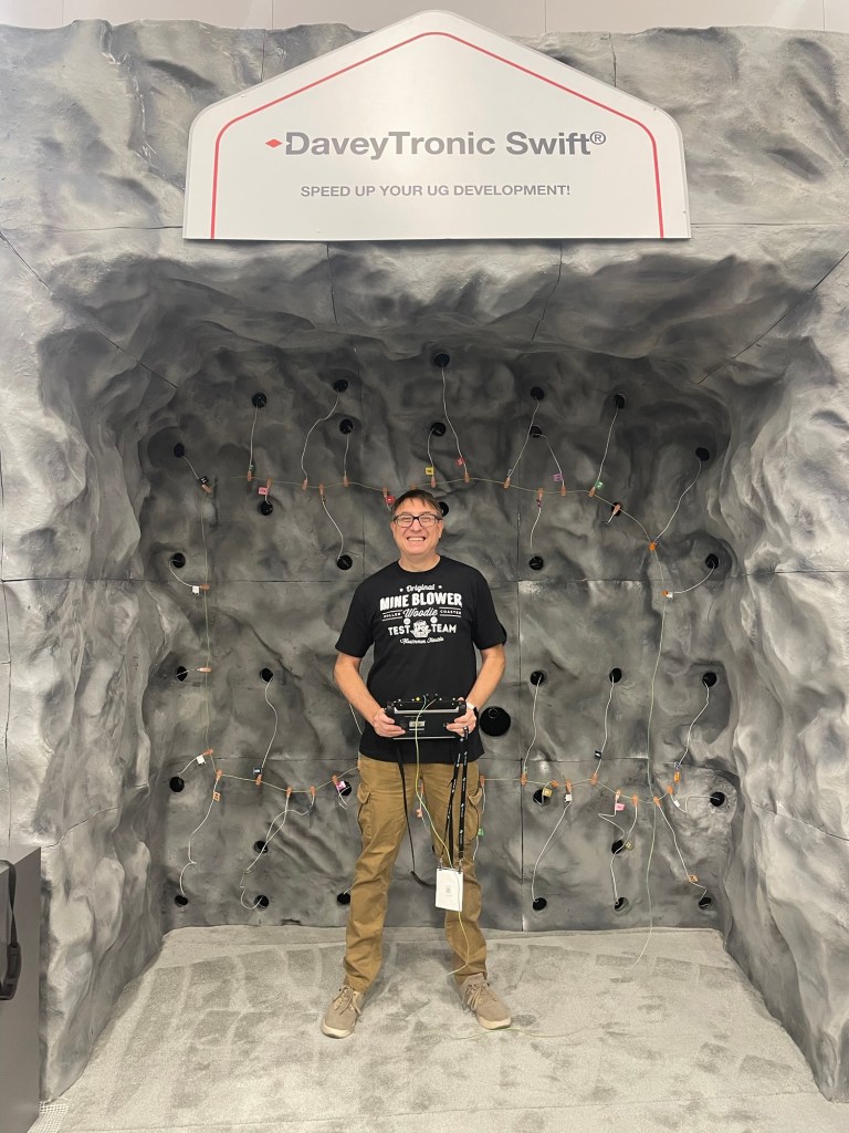 Person in front of mine explosives holding the detonator