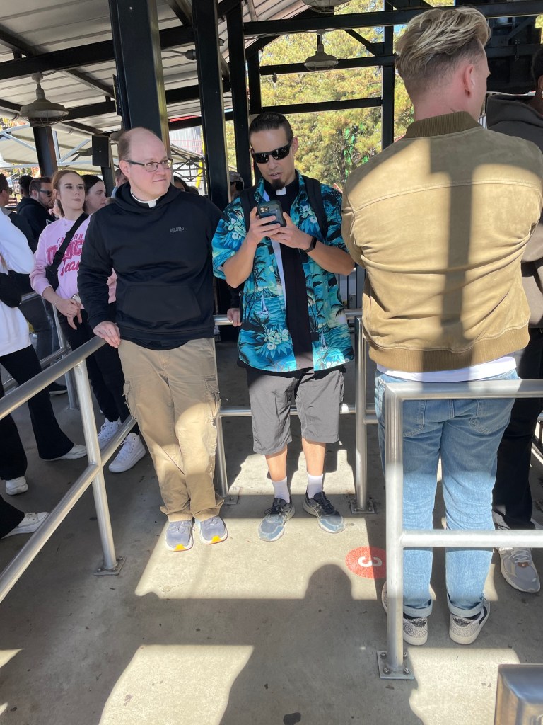 Catholic priests in line for a roller coaster