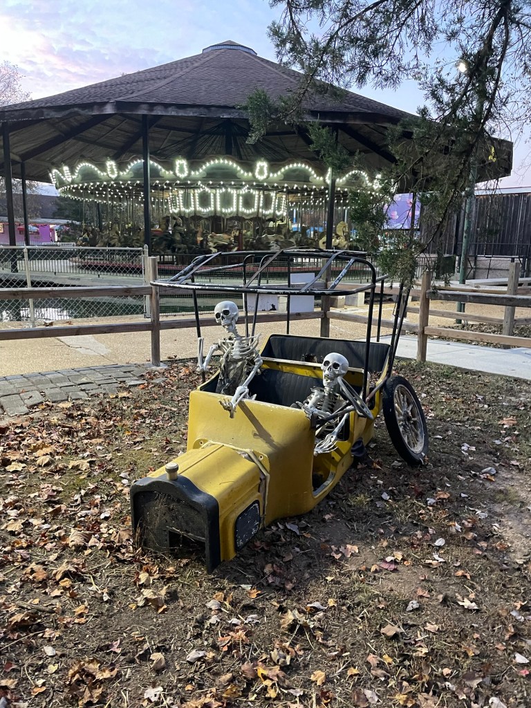 skeletons in car in front of carousel at Lake Winnie amusement park
