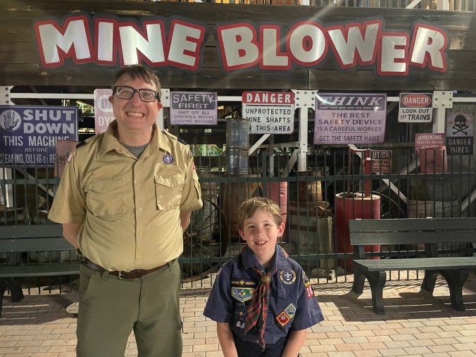 Scout leader and scout in front of the Mine Blower roller coaster at Fun Spot Kissimmee