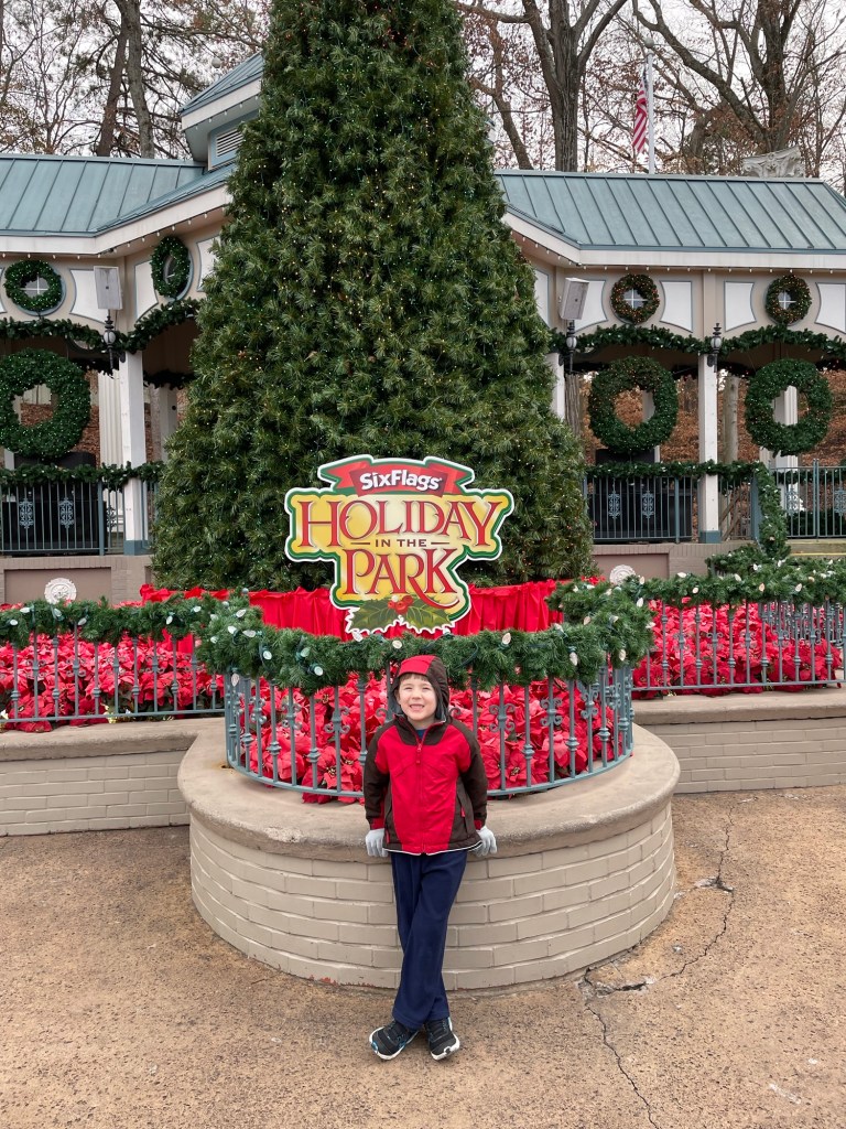 Boy in front of Christmas tree at Six Flags Over Georgia Holiday in the Park