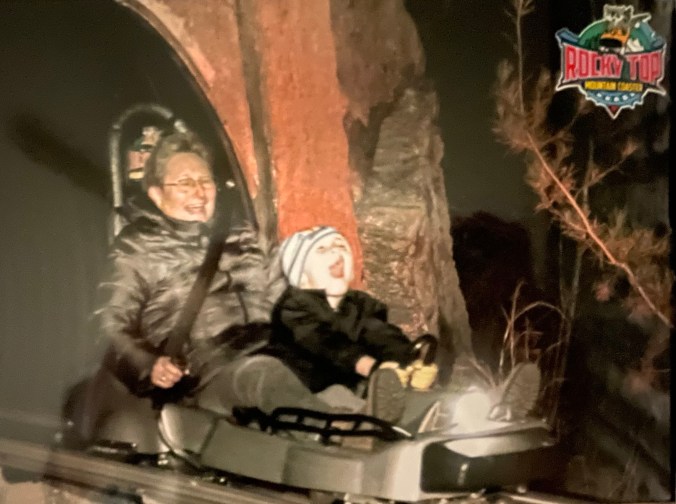 Grandma and child on Rocky Top Mountain coaster at night
